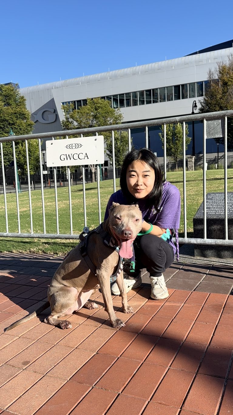 A Canine Enrichment Specialist kneeling with a dog during a walk in downtown Atlanta